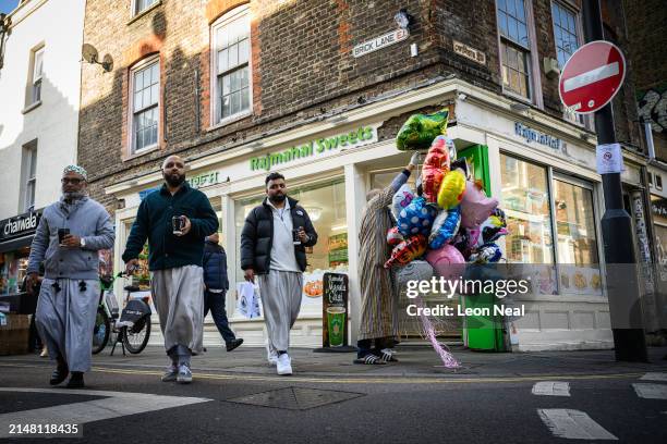 Man sorts colourful balloons outside a shop on Brick Lane as Ramadan comes to an end and Muslims around the world begin to celebrate Eid al-Fitr, on...