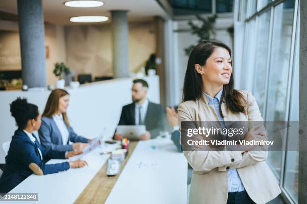 female professional leaning on office desk - round table discussion women stock pictures, royalty-free photos & images