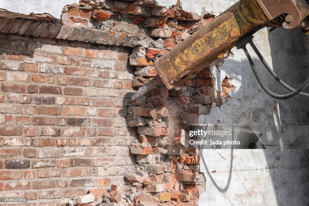 Steel hydraulic hammer is busy pulverizing stones at a demolition site