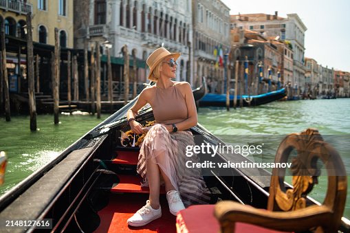 Woman on a gondola tour sailing in Grand Canal in Venice, Italy Woman on a gondola tour sailing in Grand Canal in Venice, Italy