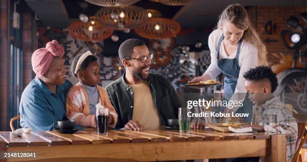 happy family, restaurant and waitress with burger for meal, dining or service at indoor cafe. woman or young employee serving food or snack with group of hungry people for menu choice at dinner table - family ordering at restaurant stock pictures, royalty-free photos & images