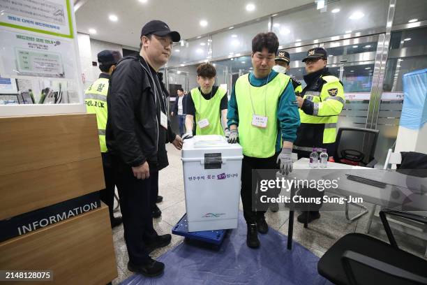 Election observers carry parliamentary voting ballot box for counting on April 10, 2024 in Seoul, South Korea. The ruling People Power Party led by...