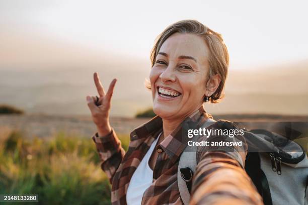 femme randonnant dans la montagne selfie avec smartphone - older pics photos et images de collection