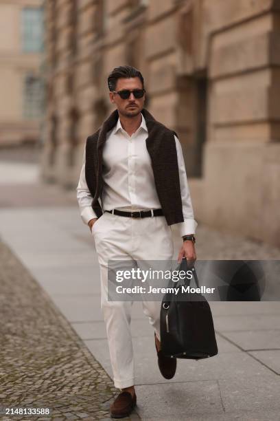 André Hellmundt seen wearing Explicit Poets brown sunglasses, Olymp white cotton buttoned shirt, Octobre Editions brown wool knit sweater, black...