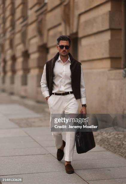 André Hellmundt seen wearing Explicit Poets brown sunglasses, Olymp white cotton buttoned shirt, Octobre Editions brown wool knit sweater, black...