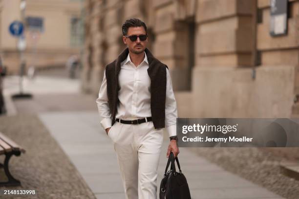 André Hellmundt seen wearing Explicit Poets brown sunglasses, Olymp white cotton buttoned shirt, Octobre Editions brown wool knit sweater, black...