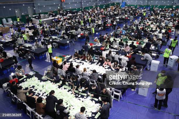 Officials from the South Korean Central Election Management Committee and election observers count votes cast of parliamentary election on April 10,...
