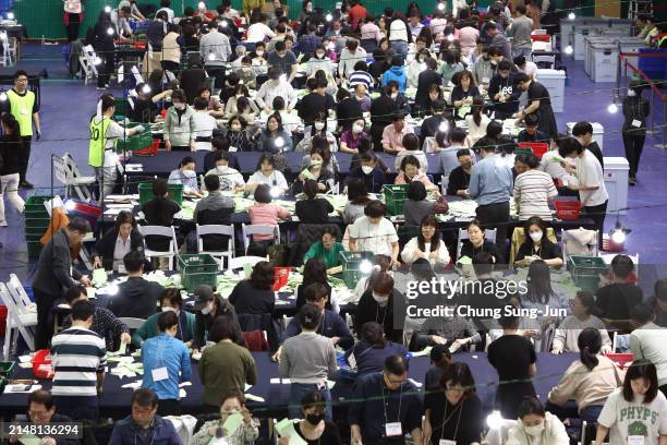 Officials from the South Korean Central Election Management Committee and election observers count votes cast of parliamentary election on April 10,...