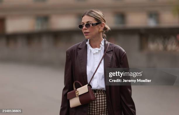 Aline Kaplan seen wearing Carolina Lemke gold sunglasses, gold earrings, Sézane white cotton ruffled button blouse / shirt, Sézane beige / brown...