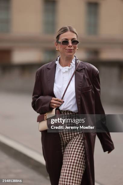 Aline Kaplan seen wearing Carolina Lemke gold sunglasses, gold earrings, Sézane white cotton ruffled button blouse / shirt, Sézane beige / brown...