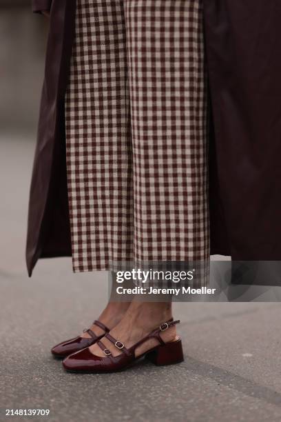 Aline Kaplan seen wearing Sézane beige / brown checked long pants, YOOX burgundy leather long coat and Sézane burgundy shiny leather heeled...