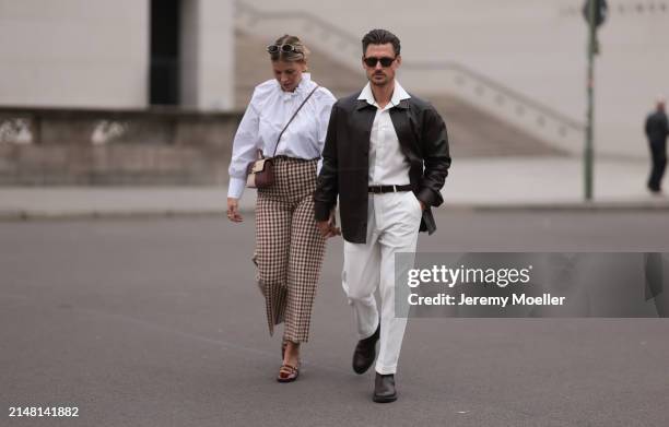 Aline Kaplan seen wearing Carolina Lemke gold sunglasses, gold earrings, Sézane white cotton ruffled button blouse / shirt, Sézane beige / brown...