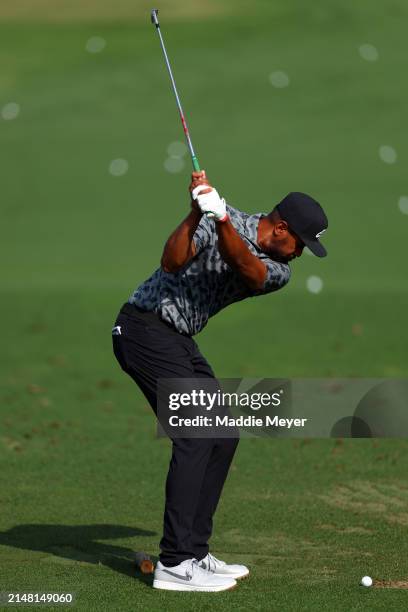 Tony Finau of the United States takes a practice shot from the driving range during a practice round prior to the 2024 Masters Tournament at Augusta...
