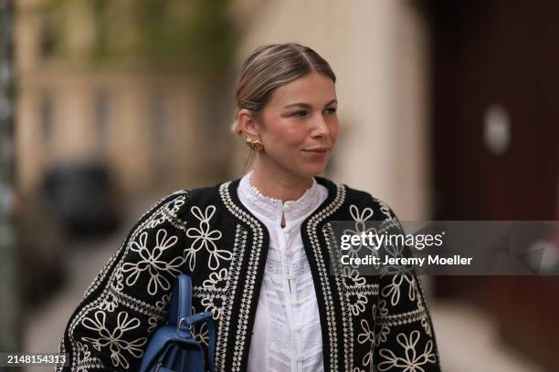 Aline Kaplan seen wearing gold heart shaped earrings, Sézane black / white flower embroidered jacket, Mango white cotton blouse, Le Tanneur blue...