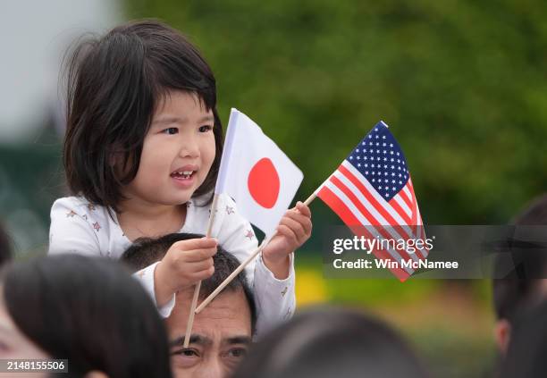 Young guest holds American and Japanese flags as they wait for the arrival ceremony for Prime Minister Fumio Kishida and Mrs. Yuko Kishida of Japan...