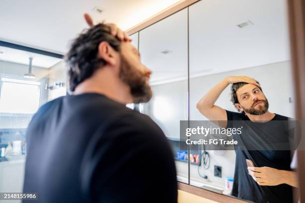 homem adulto fazendo o cabelo no banheiro de casa - man pose mirror - fotografias e filmes do acervo