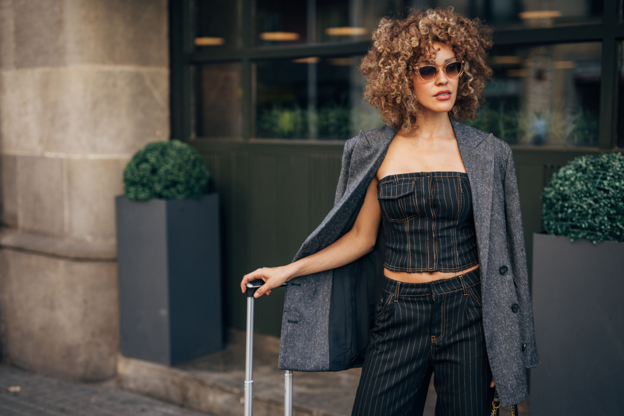 Stylish woman with suitcase on city street Stylish woman with suitcase on city street