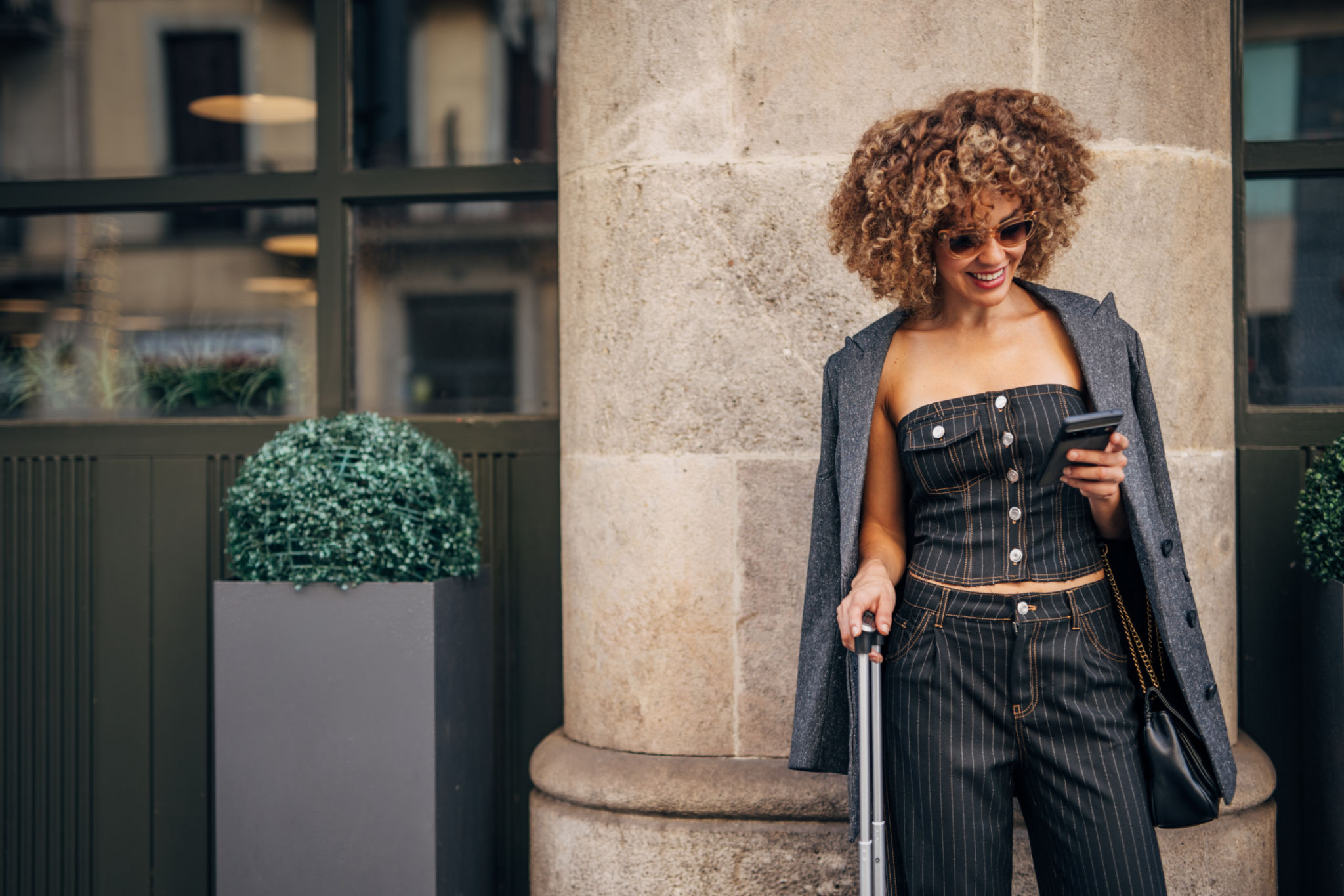 Stylish woman using smartphone on city street Stylish woman using smartphone on city street