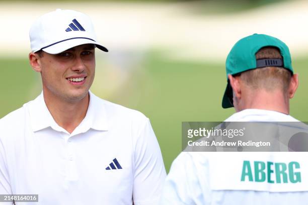Ludvig Aberg of Sweden looks on with his caddie, Joe Skovron, on the second green during a practice round prior to the 2024 Masters Tournament at...