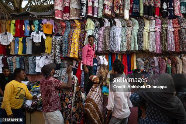 Muslim families purchase clothes on a pedestrian pavement ahead of Eid al-Fitr on April 10, 2024 in Bengaluru, India. Muslims worldwide observe the...