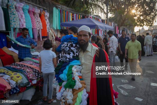 Man sells clothes on a busy street ahead of Eid al-Fitr on April 10, 2024 in Bengaluru, India. Muslims worldwide observe the Eid Al-Fitr prayer to...