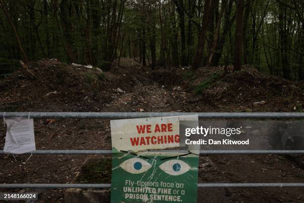 Sign, believed to have been put there by the perpetrators hangs at the blocked entrance to Hoads Wood, the scene of Illegally dumped commercial waste...