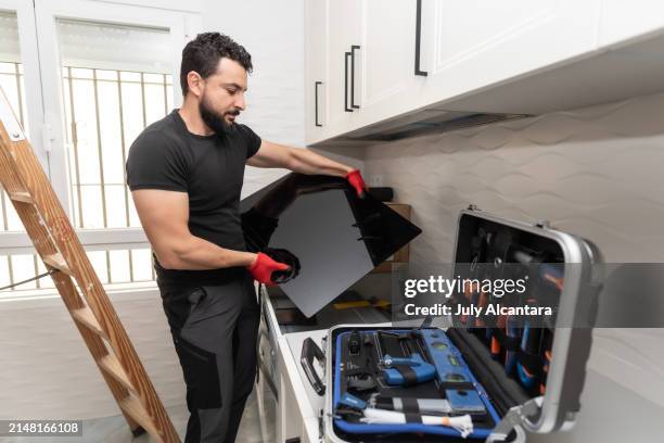 ein mann baut seine küche zusammen, indem er möbel aufstellt: vorbereitung und installation des cerankochfelds - glaskeramik stock-fotos und bilder