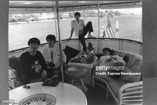 British rock group The Beatles relax on a boat off the coast of Miami, Florida, February 1964. L-R: John Lennon, George Harrison, Paul McCartney and...