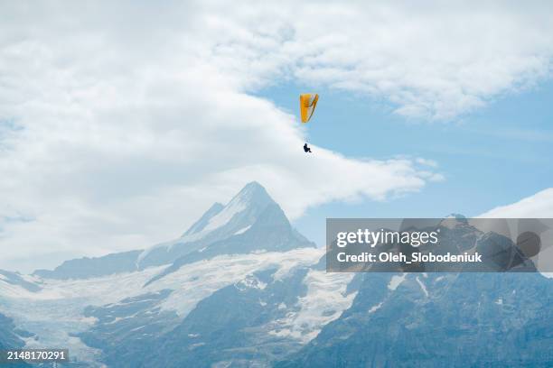 paragliding in swiss alps at sunset - parachute stock pictures, royalty-free photos & images