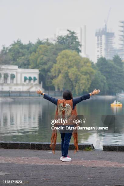portrait of a woman who feels free, opens her arms in front of a lake to embrace nature - chapultepec stock pictures, royalty-free photos & images