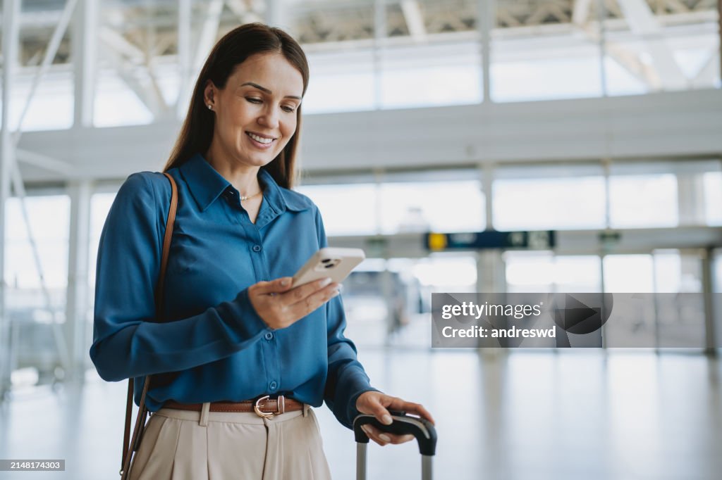 Woman at the airport holding smartphone