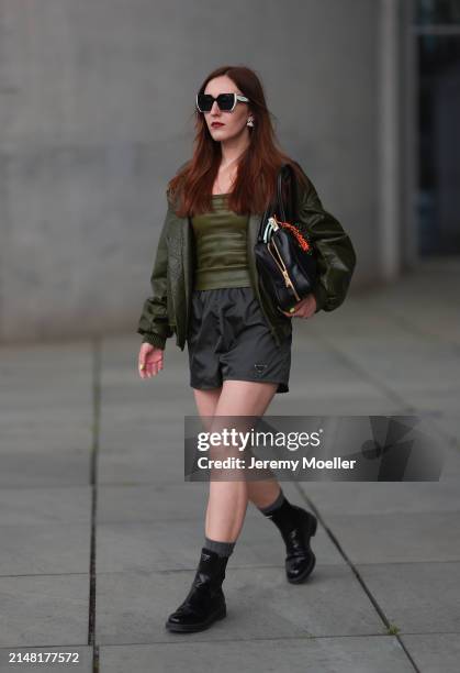 Dariia Prokopovych seen wearing Prada black / white sunglasses, khaki green leather tube top, Prada black nylon logo shorts, khaki green leather...