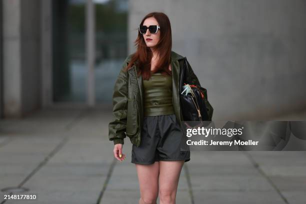 Dariia Prokopovych seen wearing Prada black / white sunglasses, khaki green leather tube top, Prada black nylon logo shorts, khaki green leather...