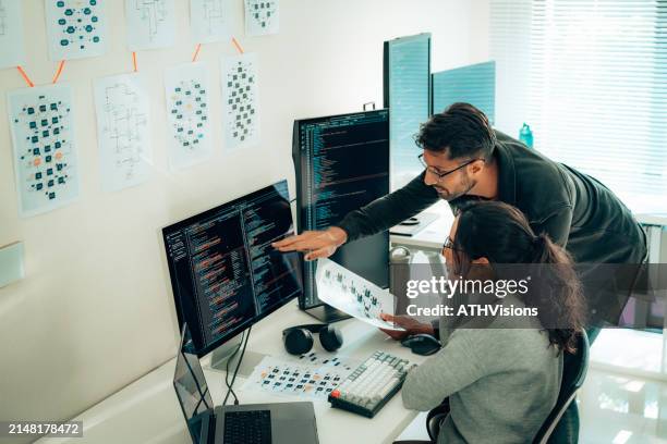hispanic programmers collaborating on software development in a modern office setting - entwicklungshilfe stock-fotos und bilder
