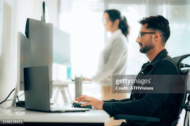 hispanic programmers collaborating on software development in a modern office setting - order stock pictures, royalty-free photos & images