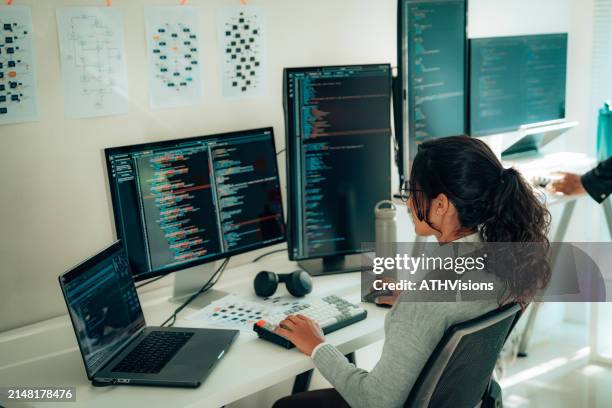donna ispanica programmatore impegnato nella codifica alla scrivania - programmazione televisiva foto e immagini stock