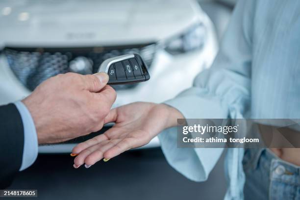 woman's hand receiving car key. - car insurance stock pictures, royalty-free photos & images