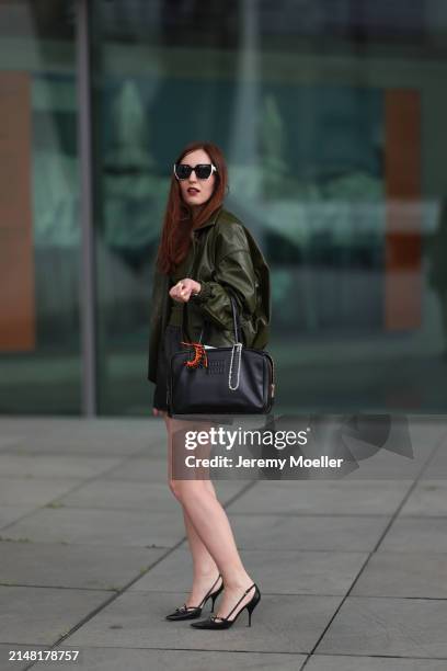 Dariia Prokopovych seen wearing Prada black / white sunglasses, khaki green leather tube top, Prada black nylon logo shorts, khaki green leather...