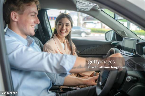 young happy couple sitting inside the car. - test drive stock pictures, royalty-free photos & images