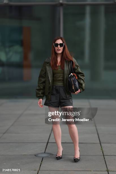 Dariia Prokopovych seen wearing Prada black / white sunglasses, khaki green leather tube top, Prada black nylon logo shorts, khaki green leather...