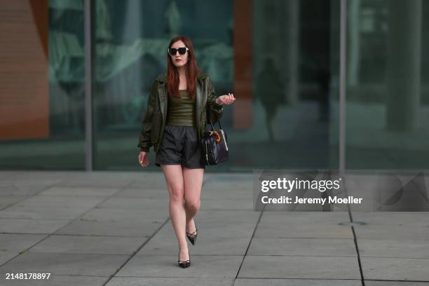 Dariia Prokopovych seen wearing Prada black / white sunglasses, khaki green leather tube top, Prada black nylon logo shorts, khaki green leather...