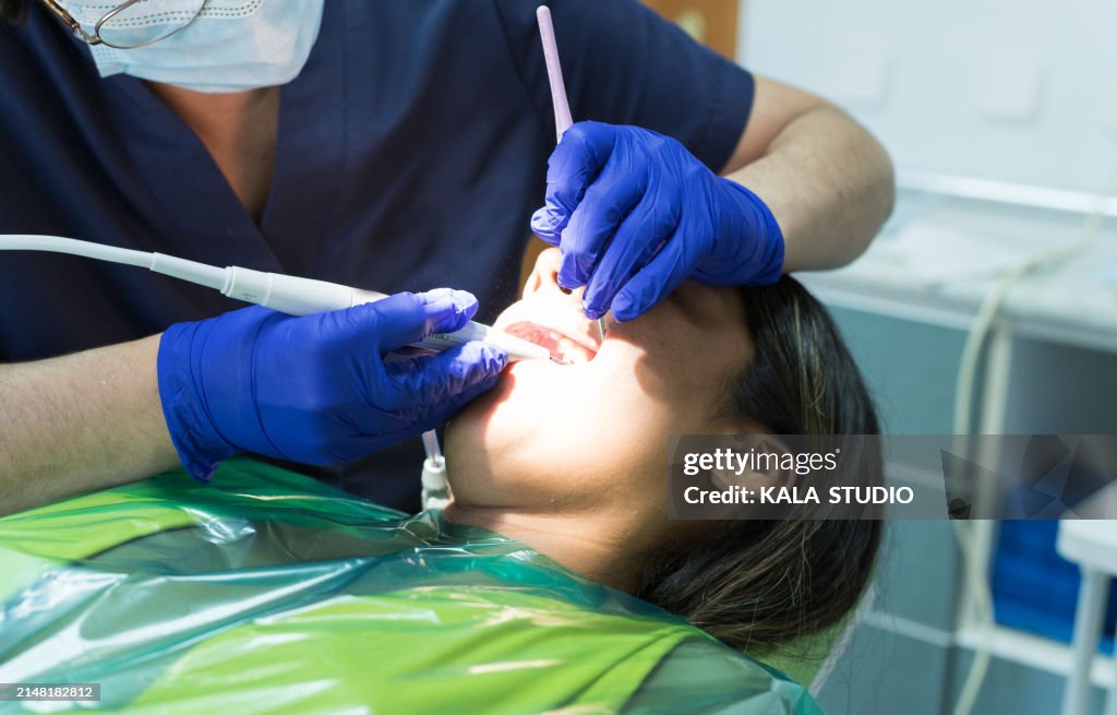 Dentist examining young woman's teeth