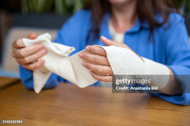 closeup photography of woman hands,using elastic bandage from pain in joint. - ace bandage stock pictures, royalty-free photos & images