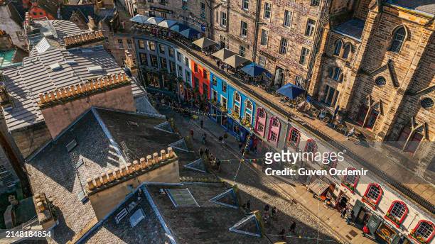aerial view of the famous colorful victoria street in the old town of edinburgh, scotland, england, victoria street in the united kingdom, victoria street in the old town in edinburgh scotland england crowds of tourists on the royal mile,harry potter city - old national centre stock pictures, royalty-free photos & images
