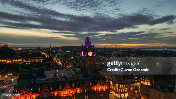 aerial view of clock tower and scottish flag in edinburgh old town, aerial view of old building in edinburgh, edinburgh city centre, gothic revival architecture in scotland, flag of scotland in edinburgh, edinburgh city scotland at night - st andrew's cross stock pictures, royalty-free photos & images