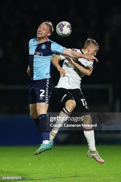 Jack Grimmer of Wycombe Wanderers and Louie Sibley of Derby County battle for a header during the Sky Bet League One match between Wycombe Wanderers...