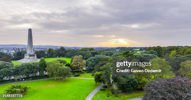 wellington monument in phoenix park in dublin ireland, famous tourist destination in ireland, landscaped park in europe, famous city parks in europe, aerial view of phoenix park at sunset, lake and city park at sunset - phoenix park dublin stock pictures, royalty-free photos & images