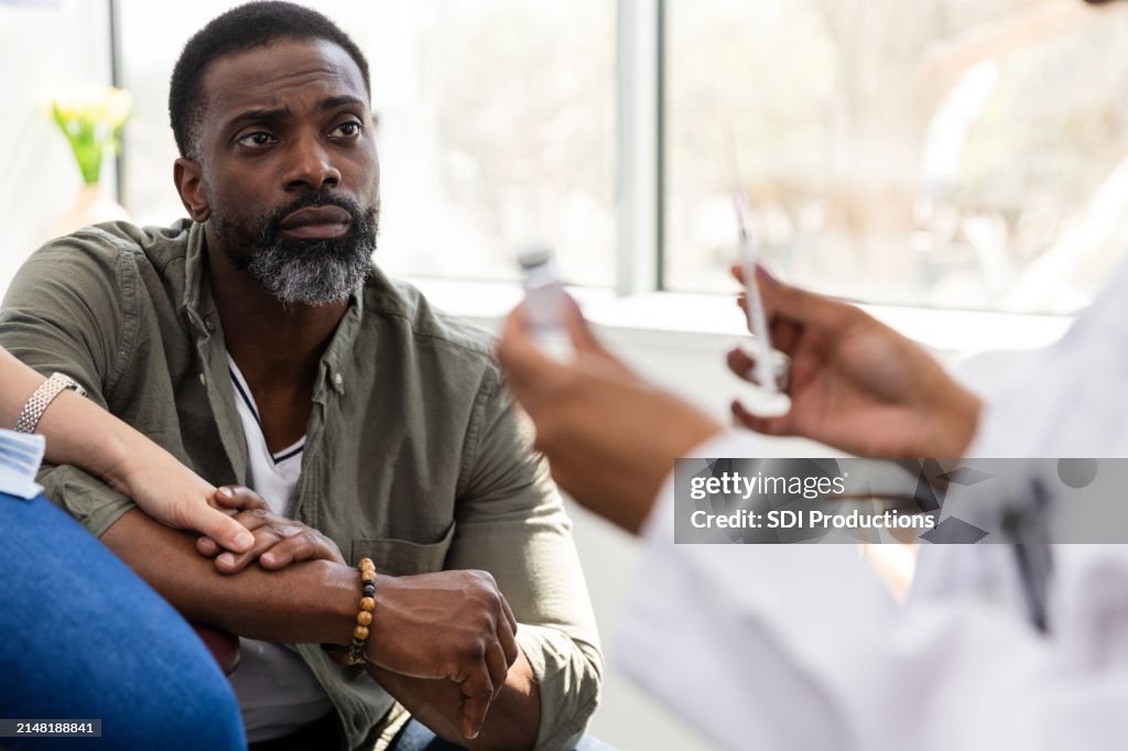 Concéntrese en el esposo que observa al endocrinólogo dando instrucciones a la esposa irreconocible