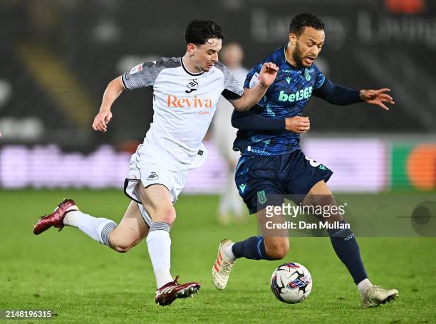 Charlie Patino of Swansea City battles for possession with Lewis Baker of Stoke City during the Sky Bet Championship match between Swansea City and...