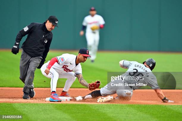Second base umpire David Rackley watches as shortstop Brayan Rocchio of the Cleveland Guardians misses the tag on Robbie Grossman of the Chicago...